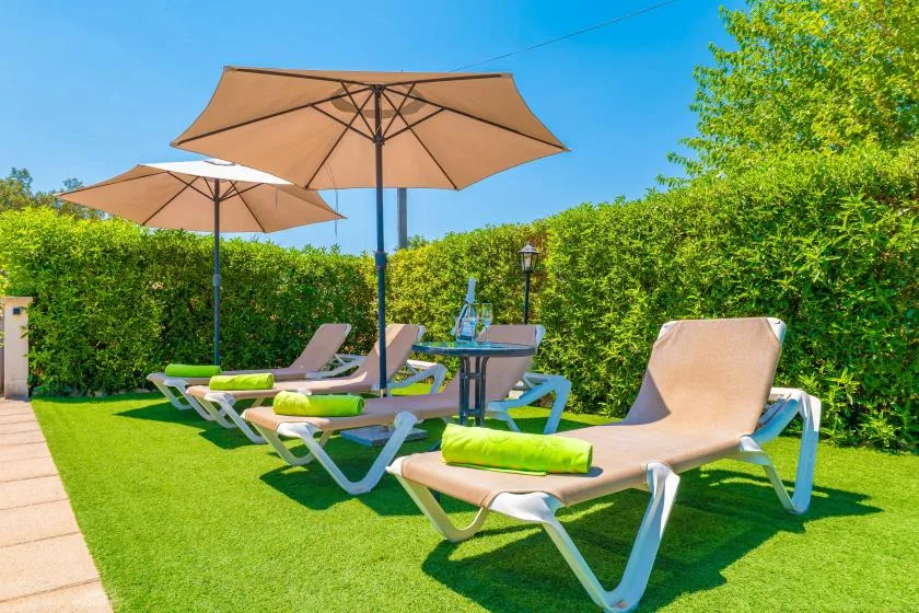 An outdoor patio seating area with lounge chairs beneath large umbrellas.