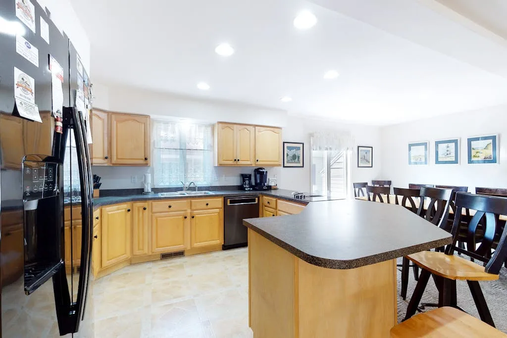 A bright kitchen with wooden cabinets, a central island, and dining seating.