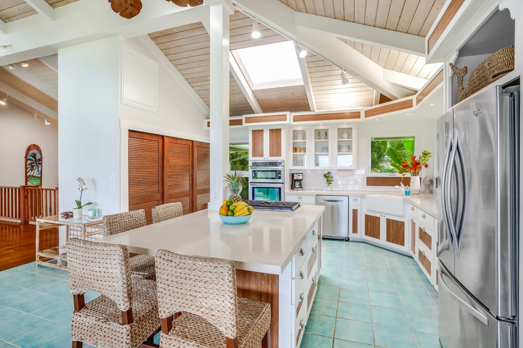 Una cocina luminosa con una isla central y electrodomésticos de acero inoxidable.