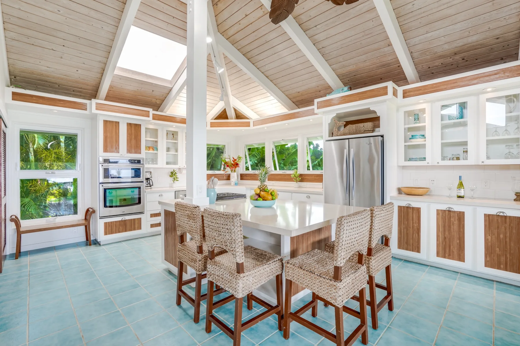Una cocina y comedor luminosos con una isla central y asientos tejidos.
