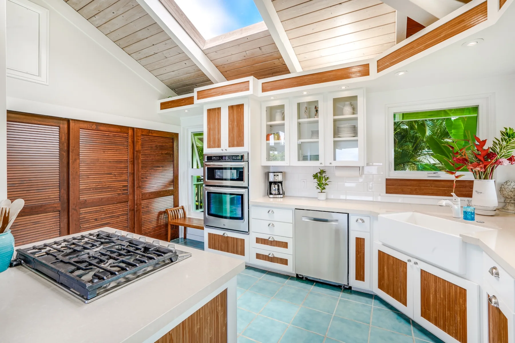 Una cocina luminosa con gabinetes blancos, una estufa y tragaluces.