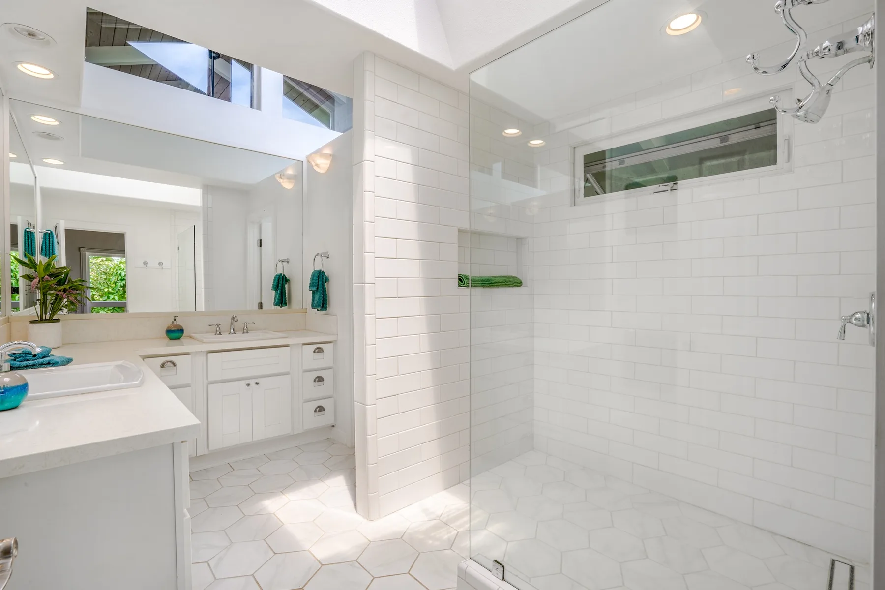 Un baño luminoso con lavabo y ducha de vidrio.