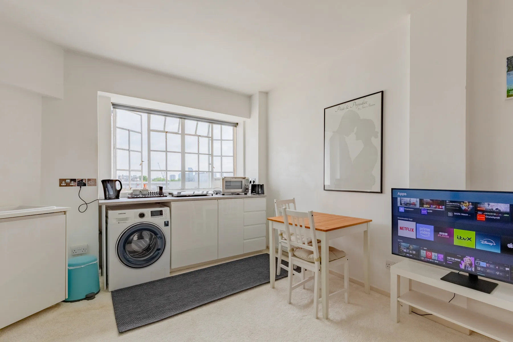 A bright kitchen and dining area with a television beside the table.