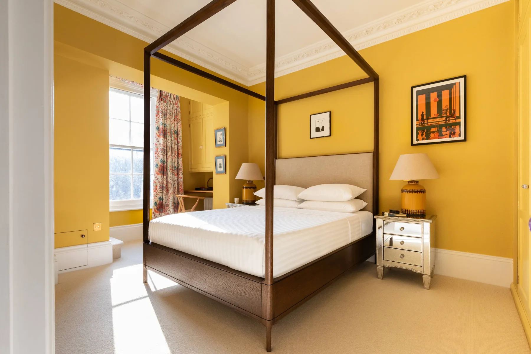 A bedroom with a four-poster bed and yellow walls.