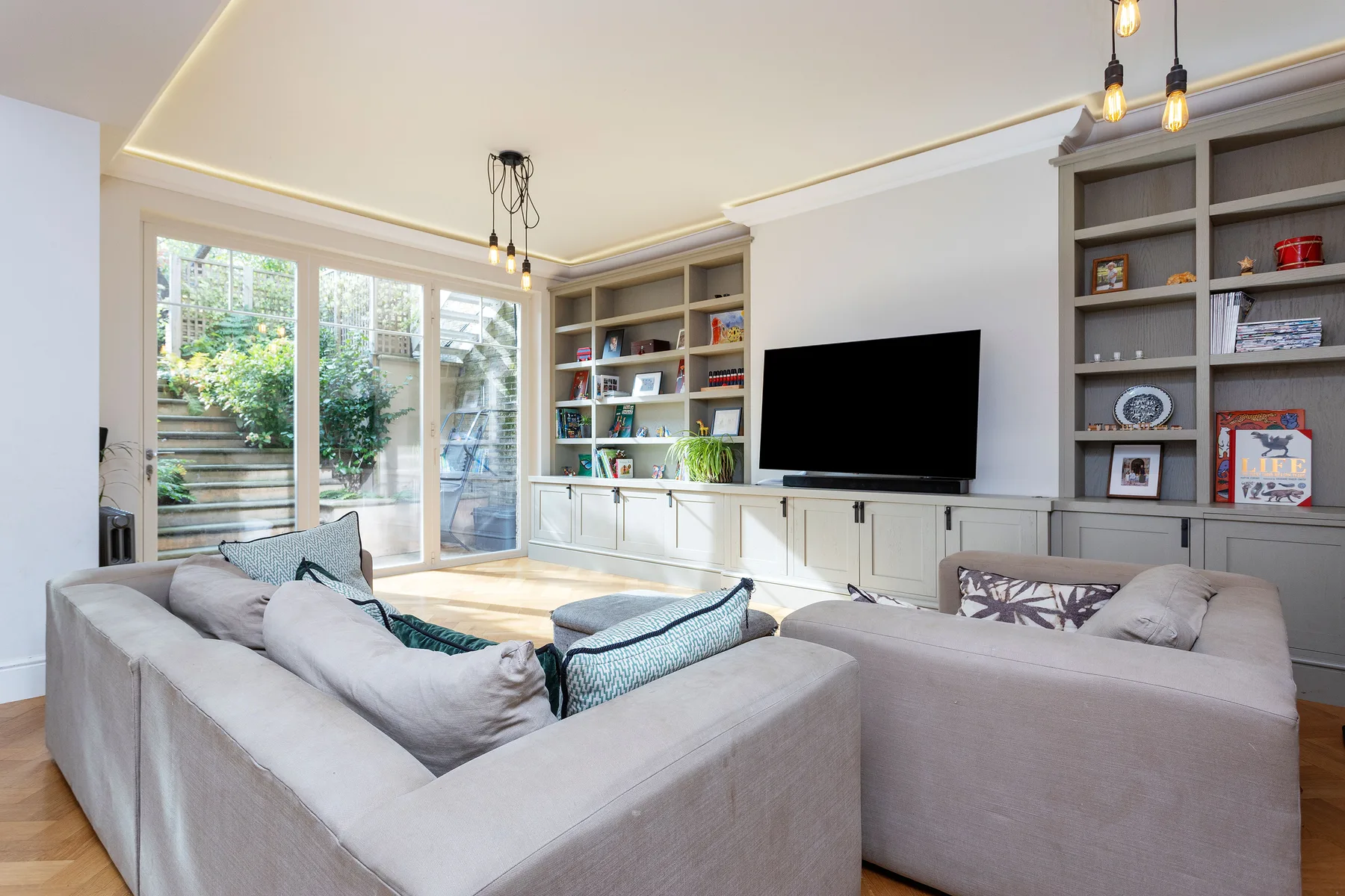 A living room with seating arranged around a television and built-in shelves.