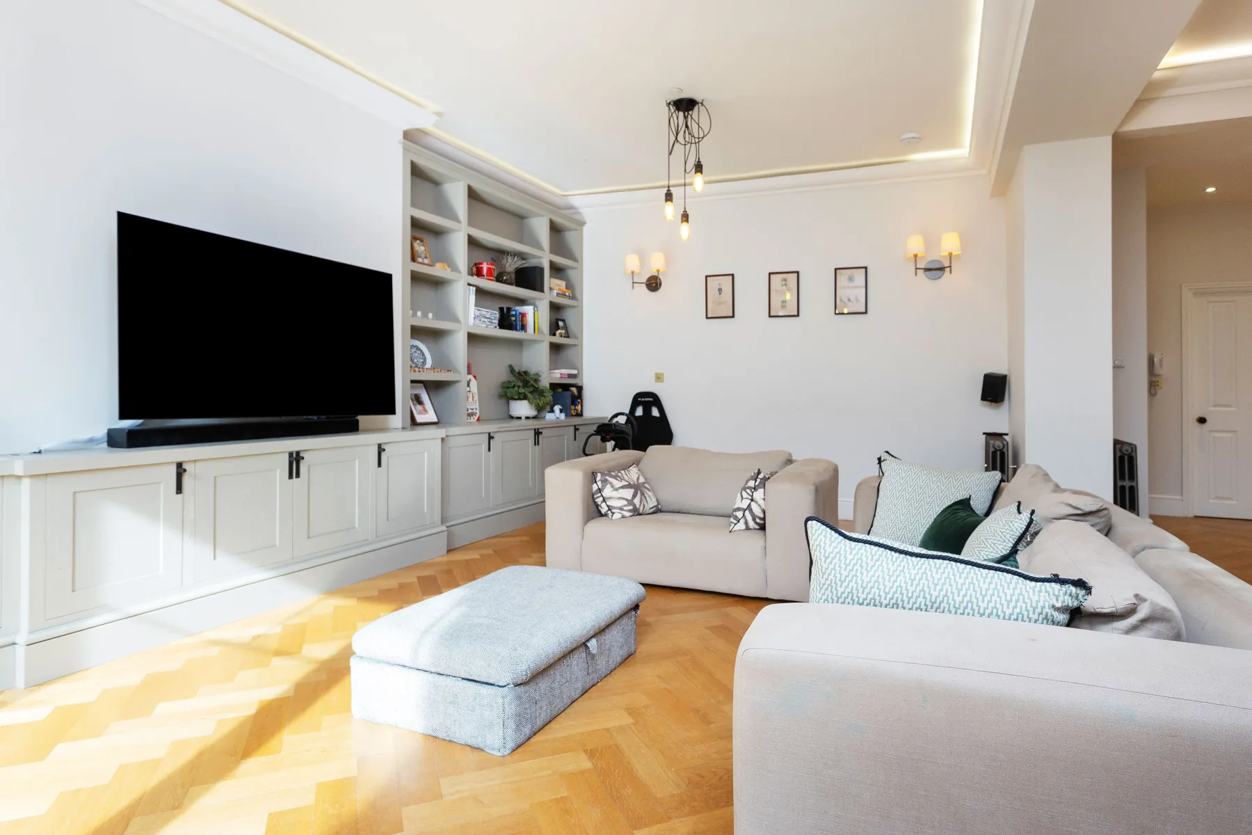 A living room with built-in shelving, a television, and seating.