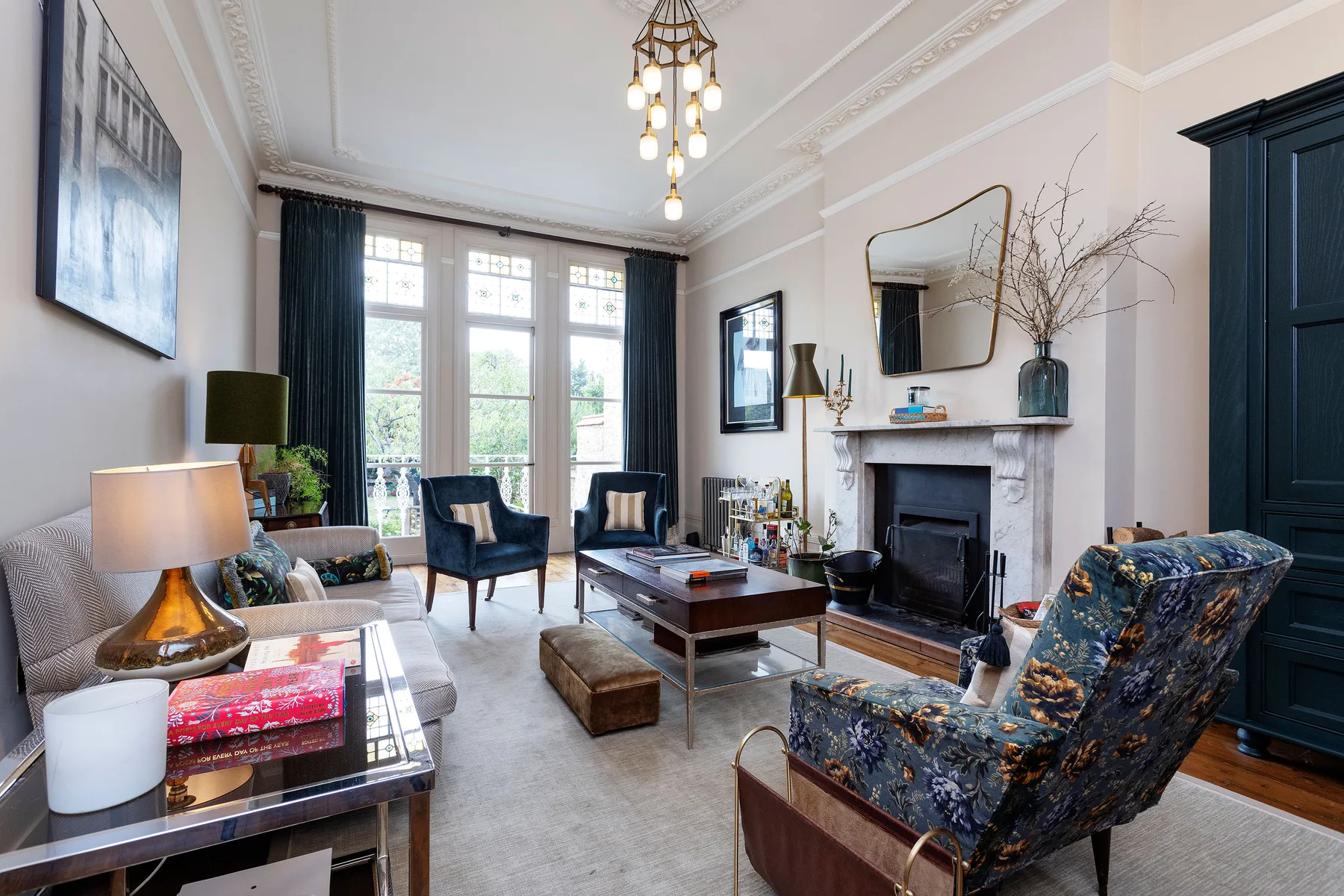 A bright living room with seating arranged around a fireplace and coffee table.