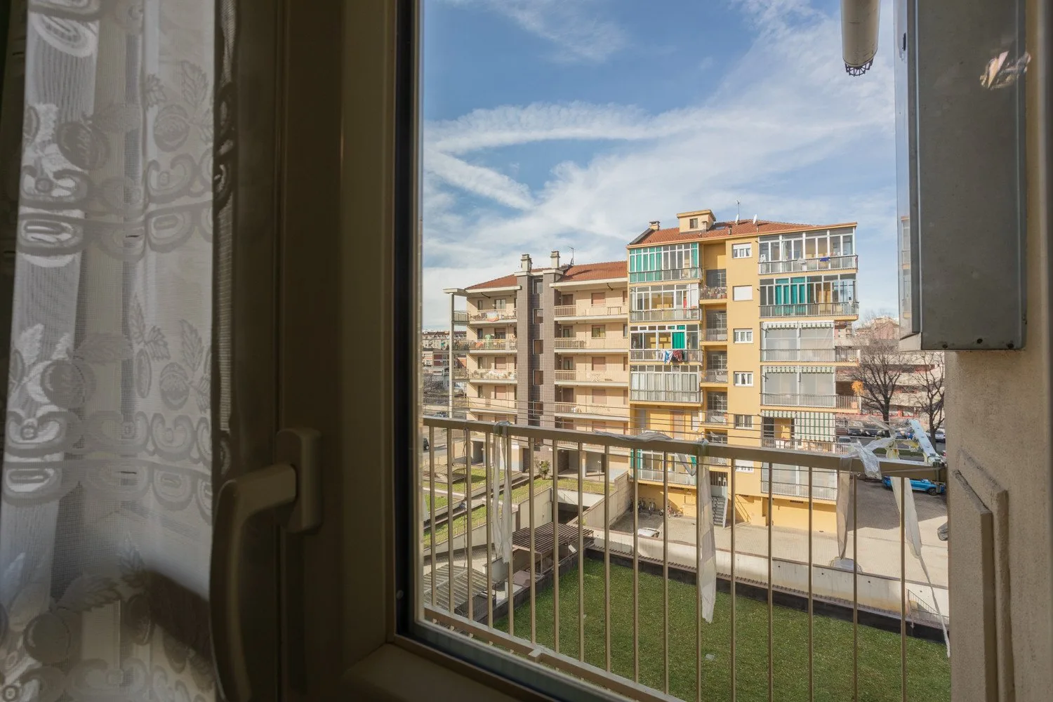 View of neighboring apartment buildings and a courtyard from a window.