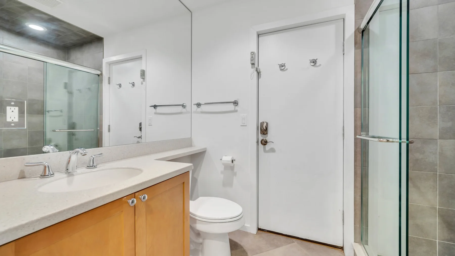 Un baño con lavabo, inodoro y ducha de vidrio.