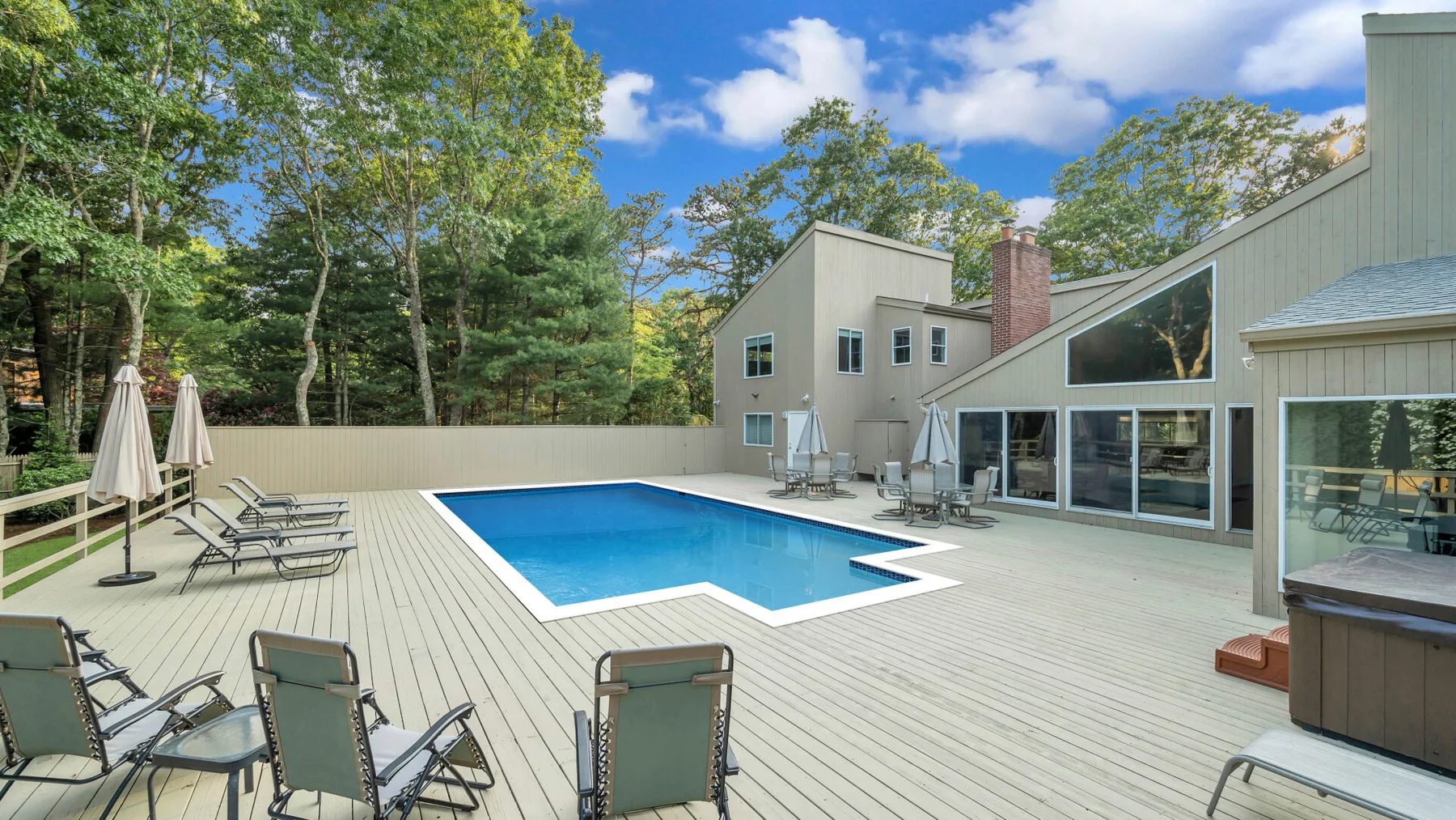 Una piscina exterior está junto a una amplia terraza con asientos.