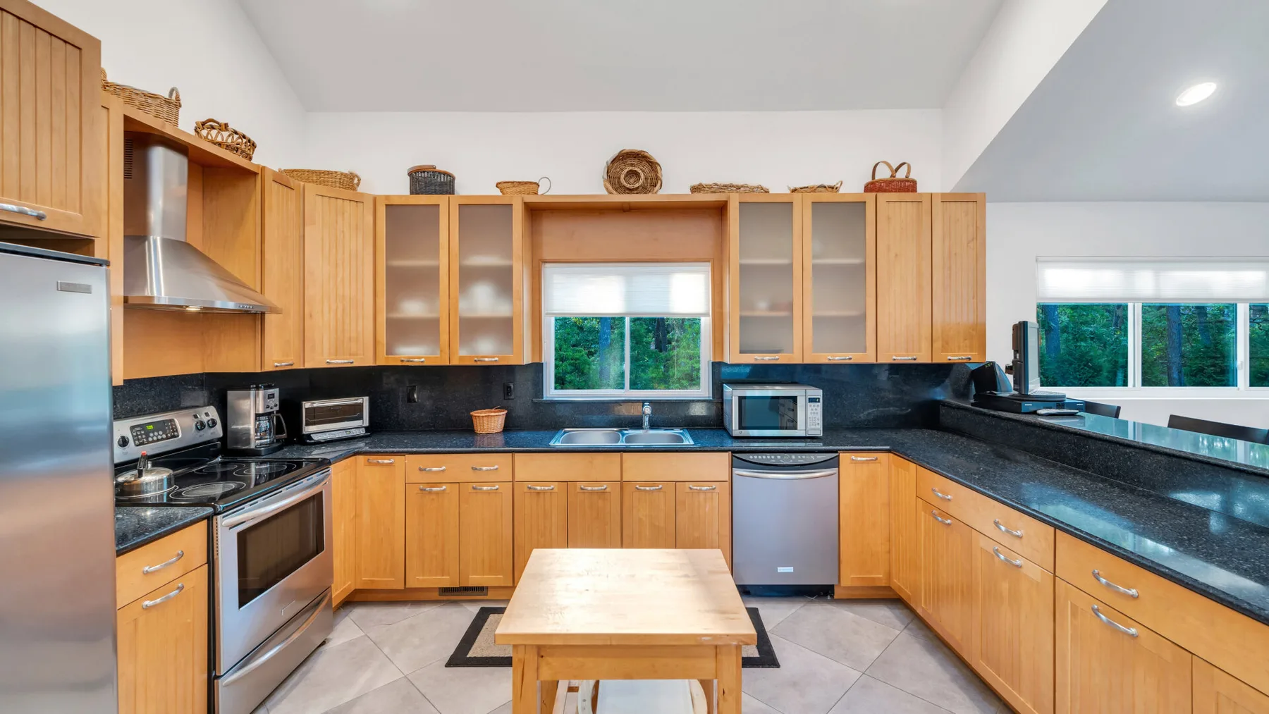 Una cocina amplia con gabinetes de madera, encimeras oscuras y una isla central.