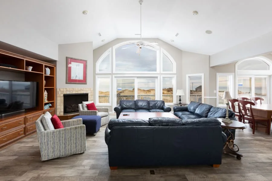 A living room with a sectional seating area facing large arched windows.