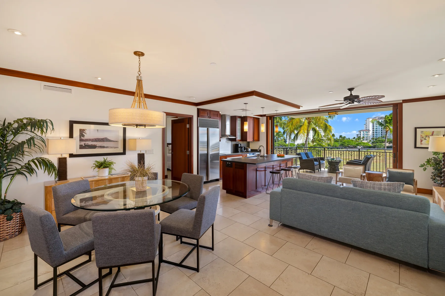 Sala-comedor de planta abierta con asientos junto a una cocina y un balcón.