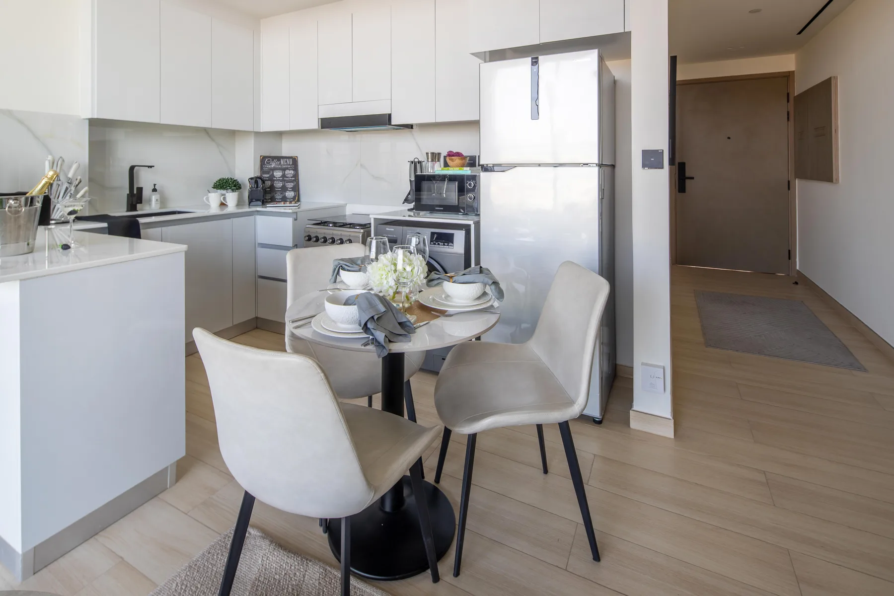 A bright kitchen and dining area with a round table set for a meal.