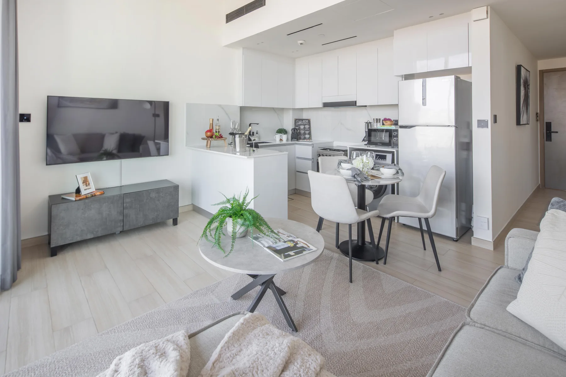 Una sala de estar de planta abierta con mesa de comedor y cocina luminosa.