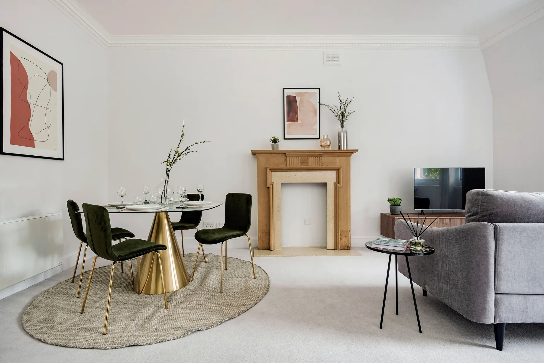 A bright living and dining room with a fireplace, table, and seating.
