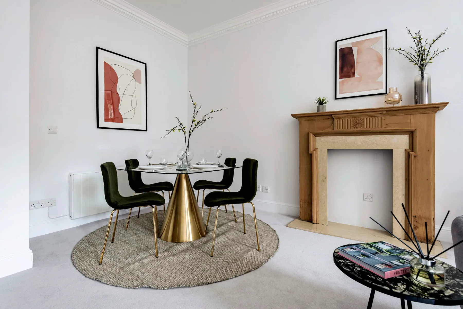 A dining area with a round table and black seating beside a wooden fireplace.
