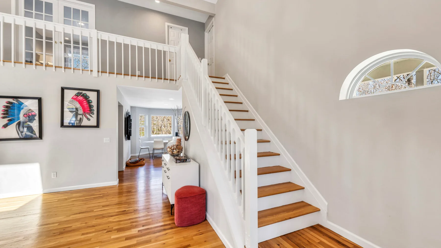 A bright interior hallway with a staircase leading to an upper landing.