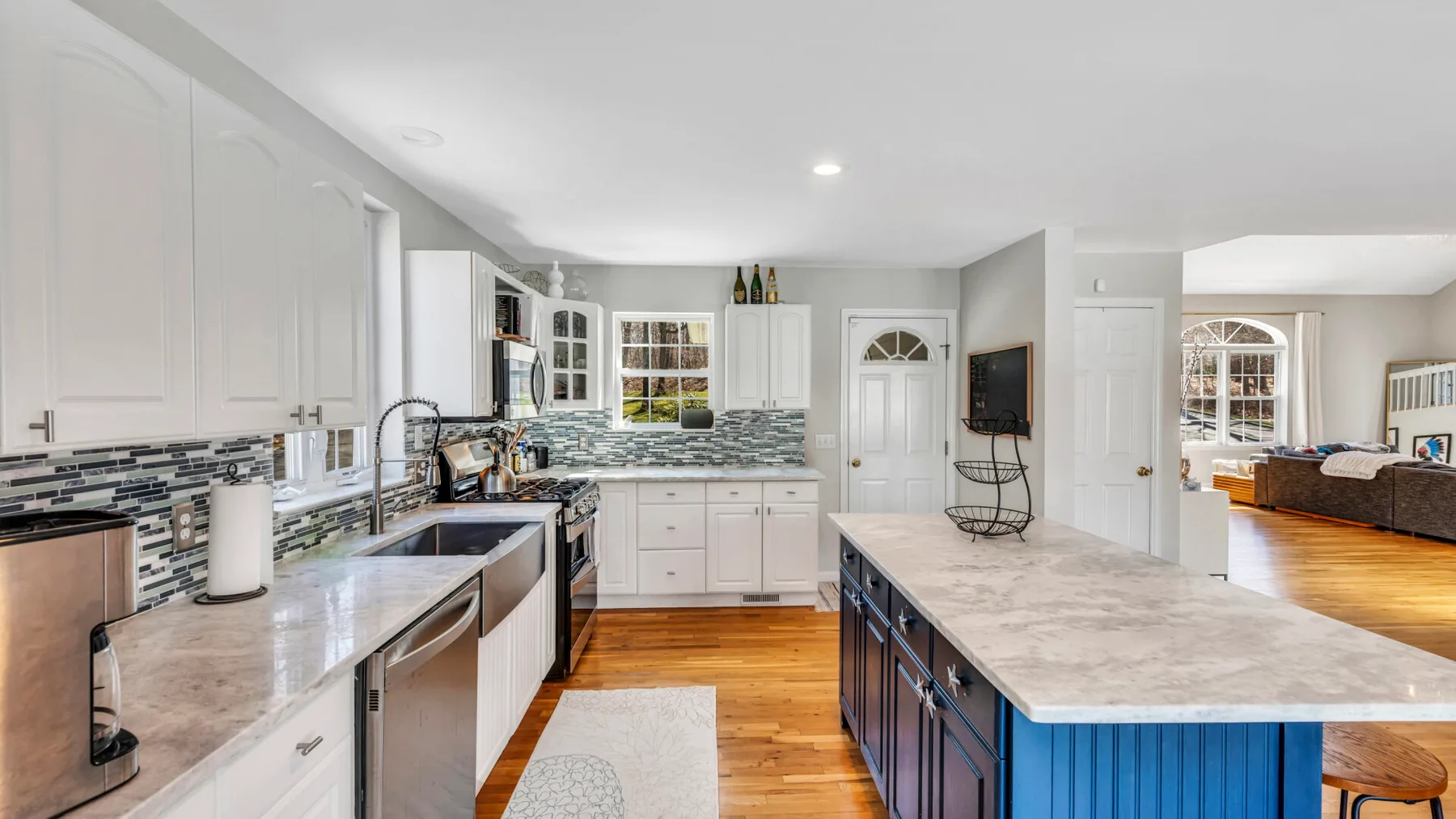A bright kitchen with white cabinetry and a large island.