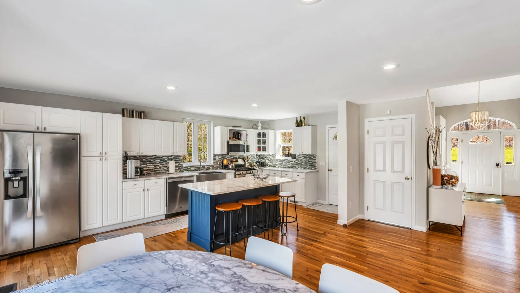 A bright kitchen with a central island and stainless steel appliances.