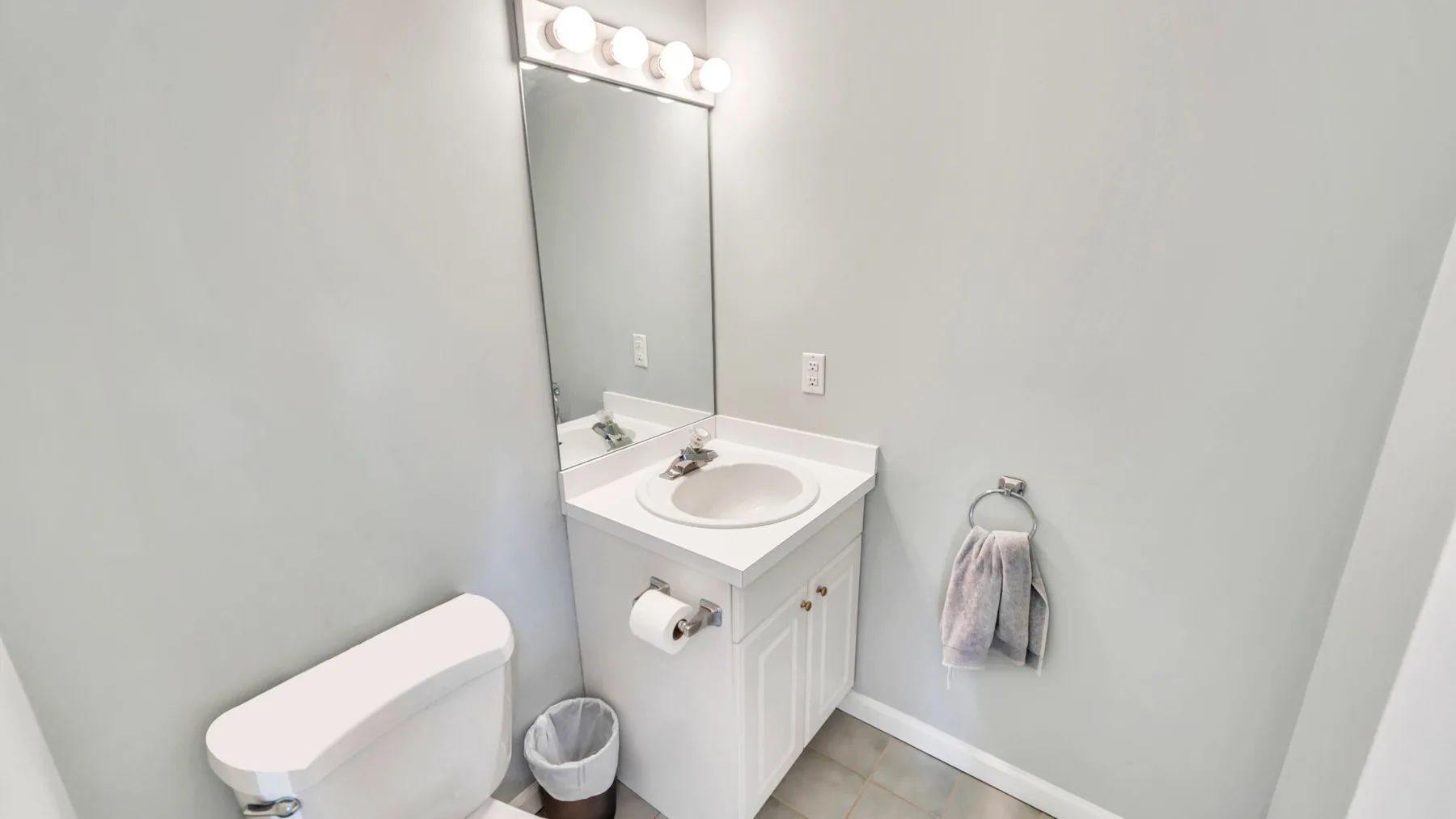 A bathroom vanity with a sink and illuminated mirror.