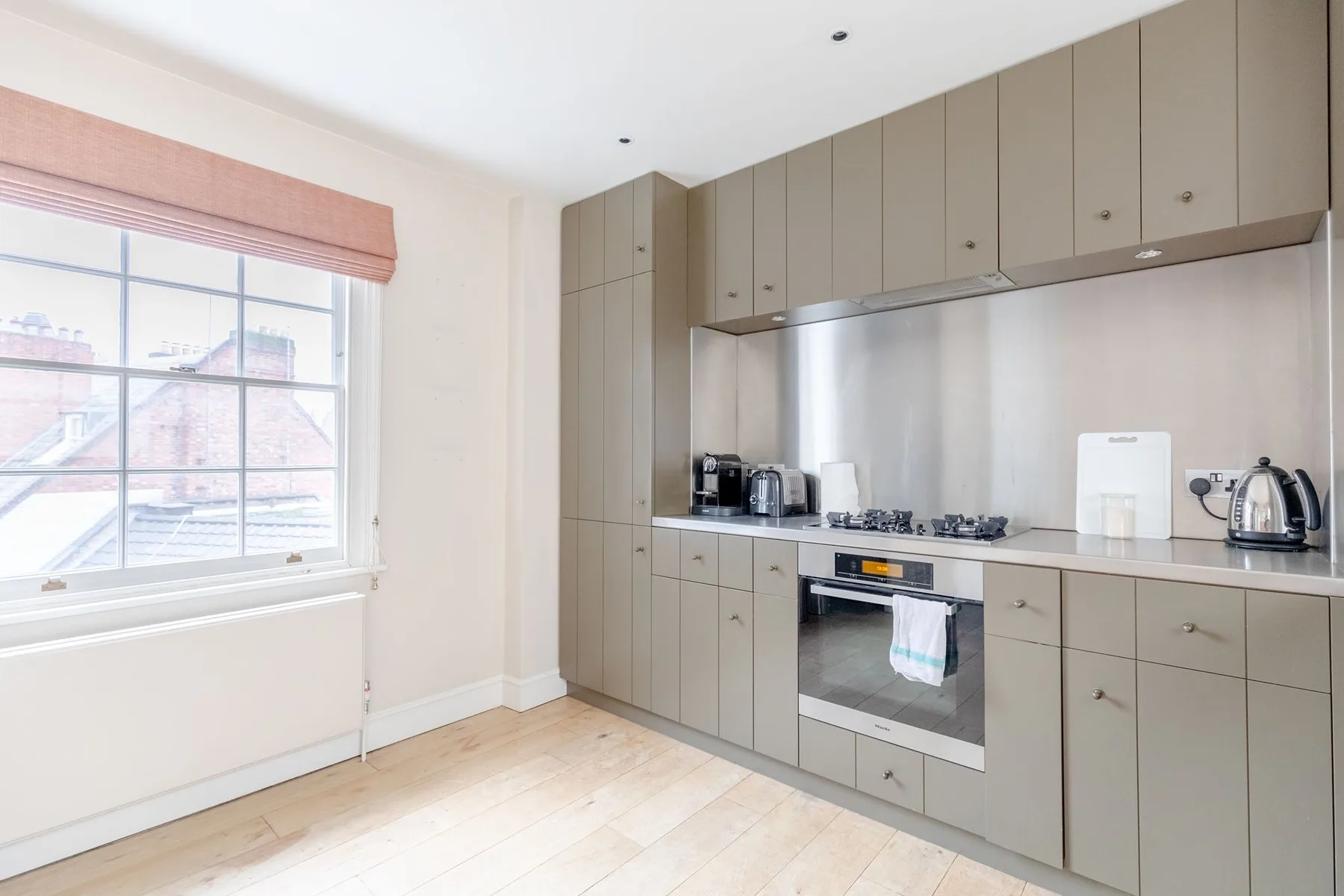 Una cocina moderna con gabinetes grises, una estufa y una ventana grande.