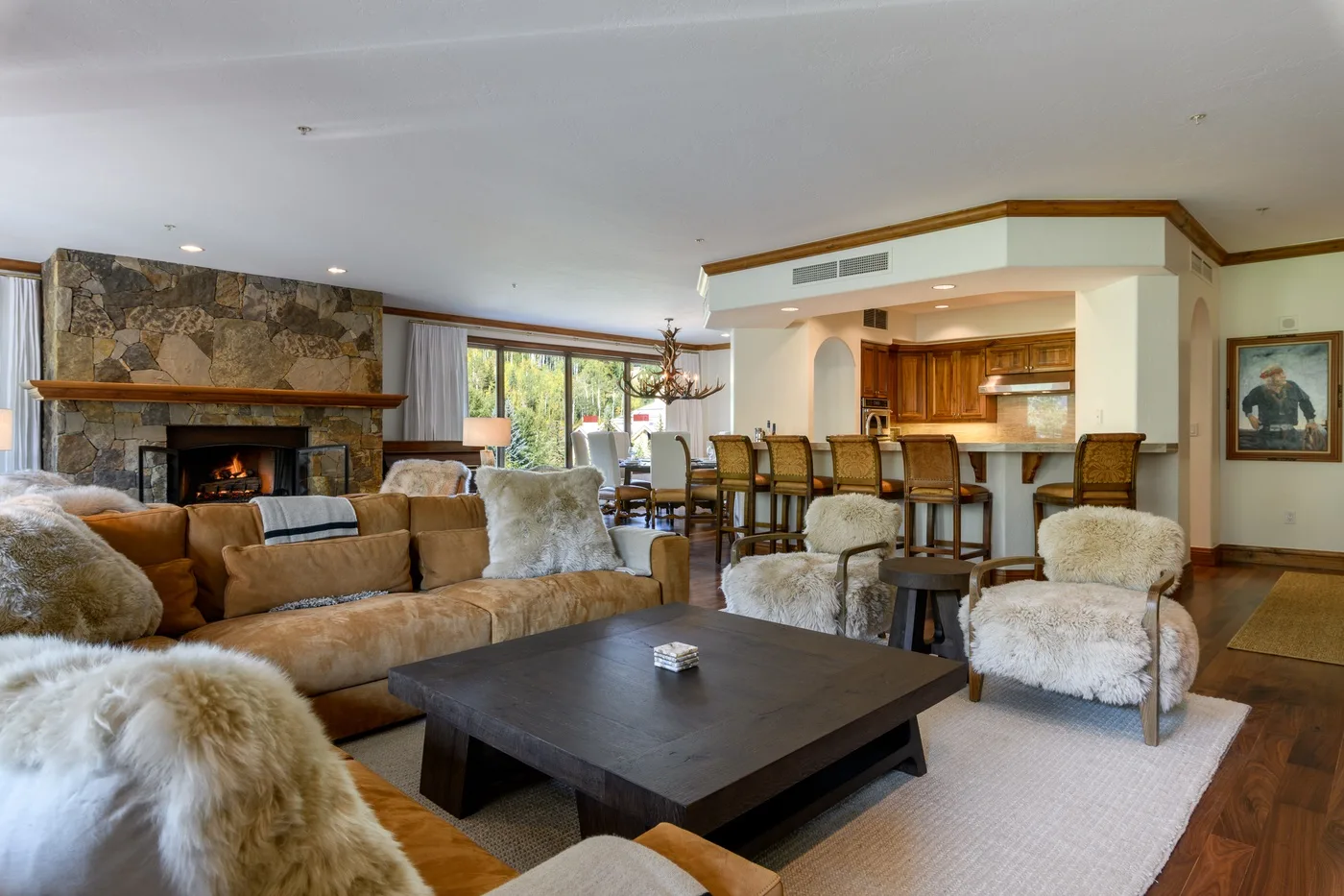 Living room with seating, a fireplace, and an open kitchen.