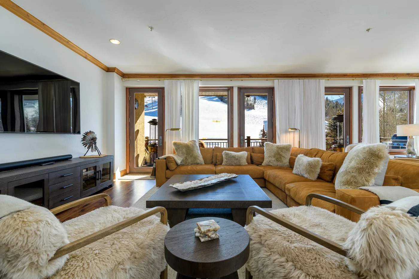 A bright living room with a sectional seating area and wide windows.