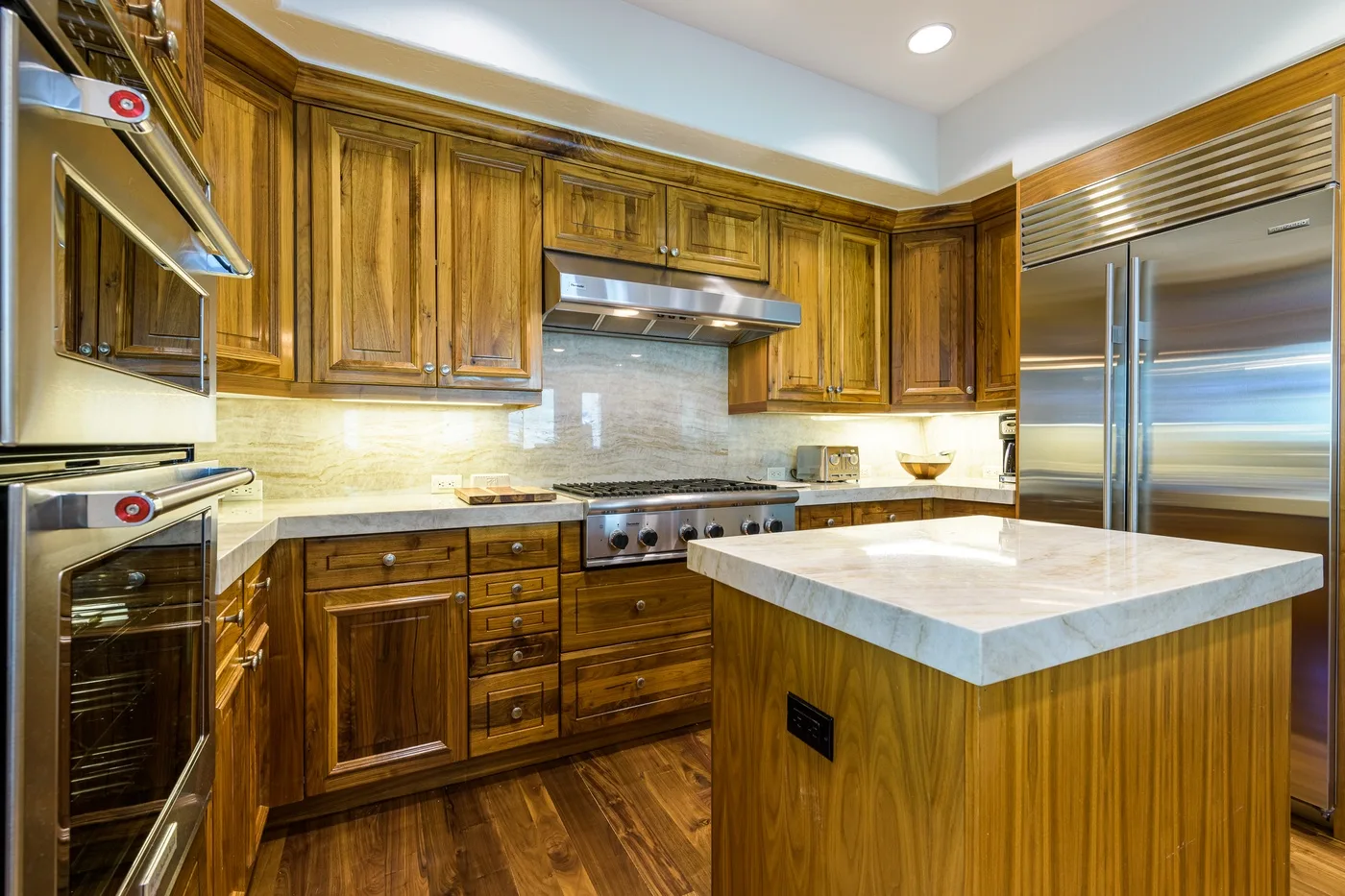 A kitchen with wooden cabinetry, stainless steel appliances, and a central island.