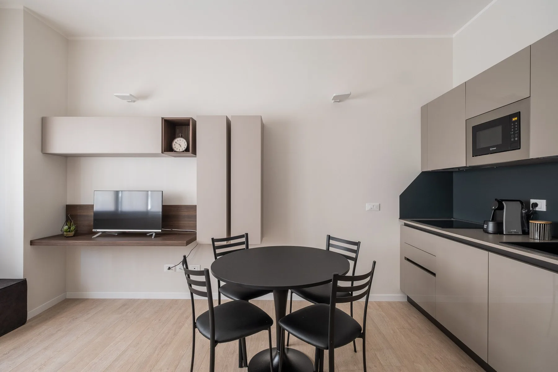 Comedor con una mesa redonda y una cocina compacta junto a la pared.