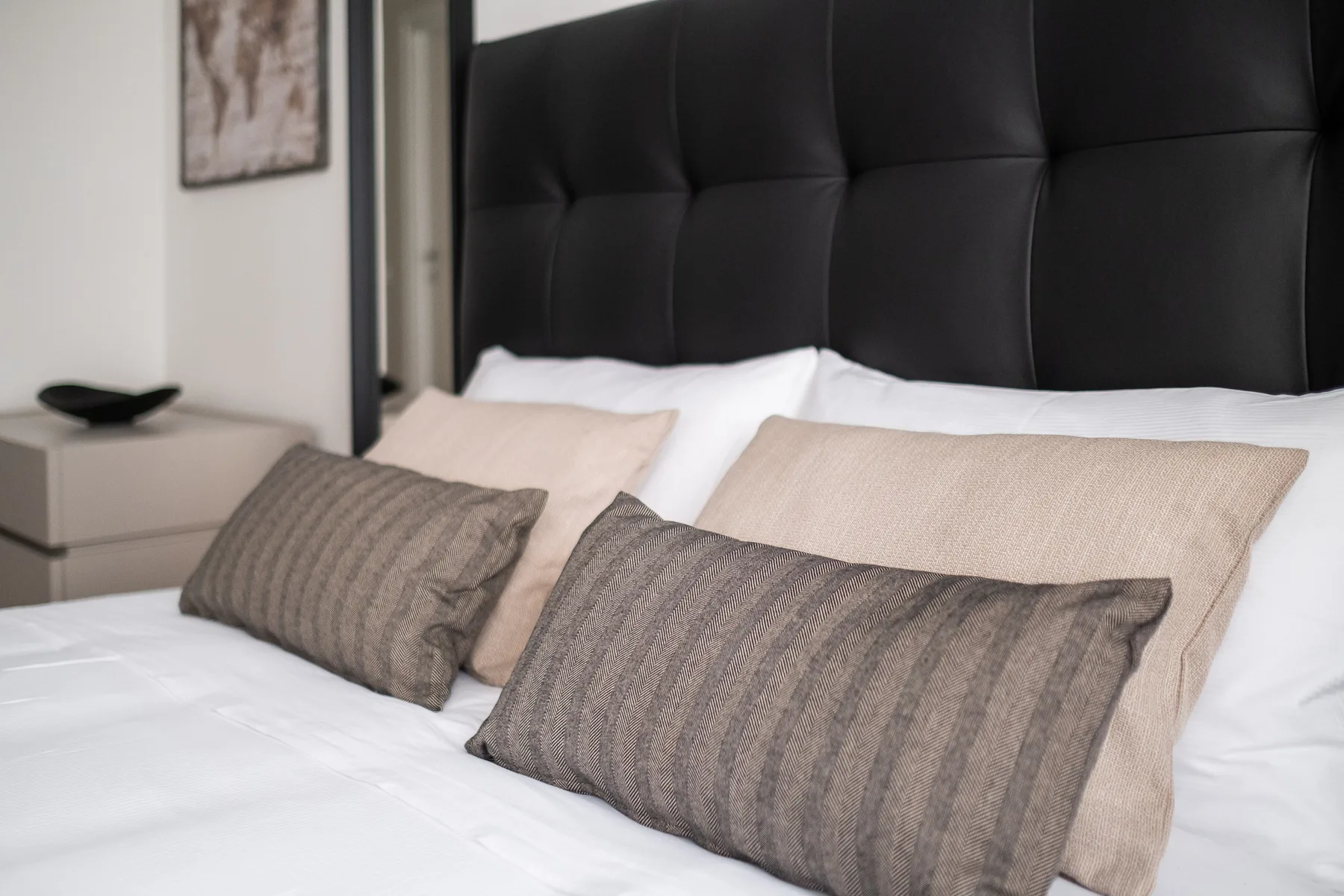 Un dormitorio con almohadas superpuestas sobre una cama bien hecha.