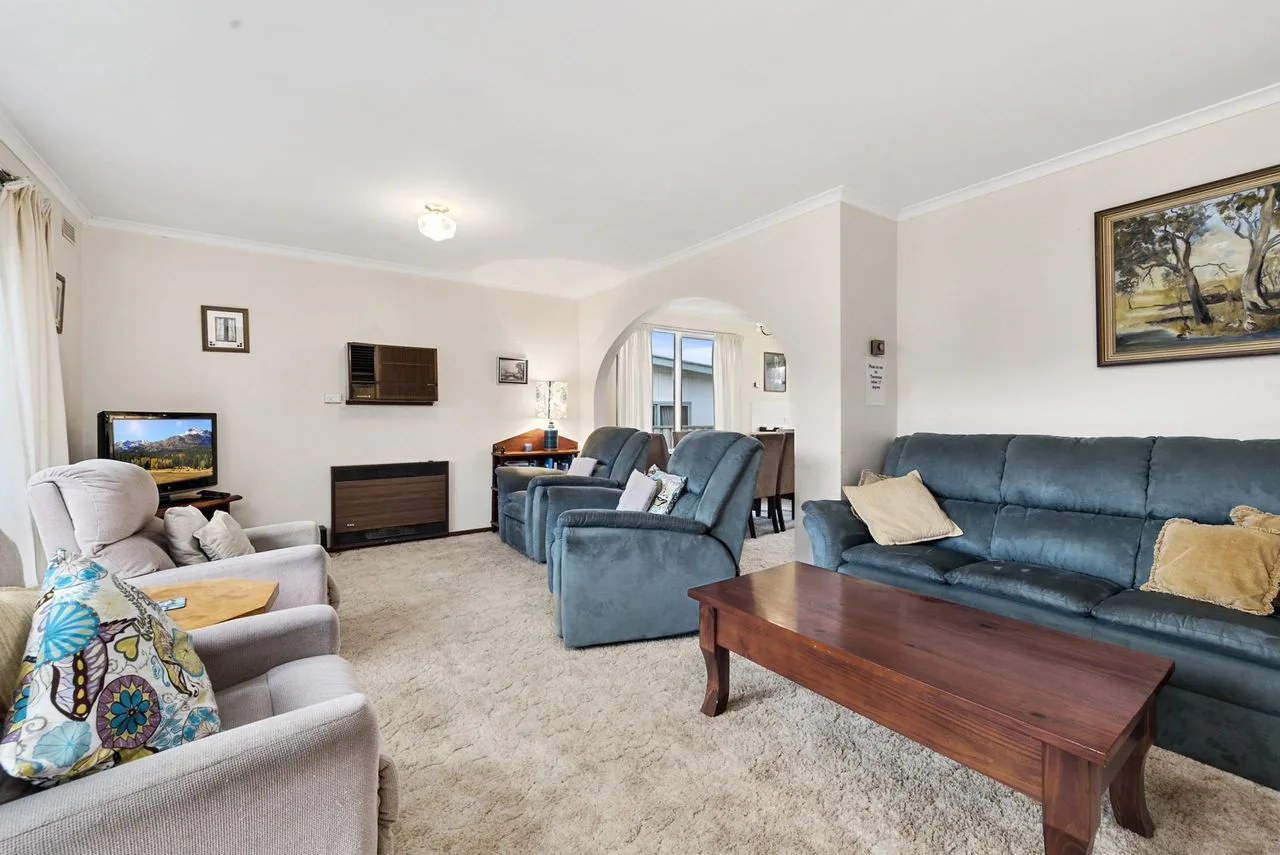 A living room with sofas, a television, and a wooden coffee table.