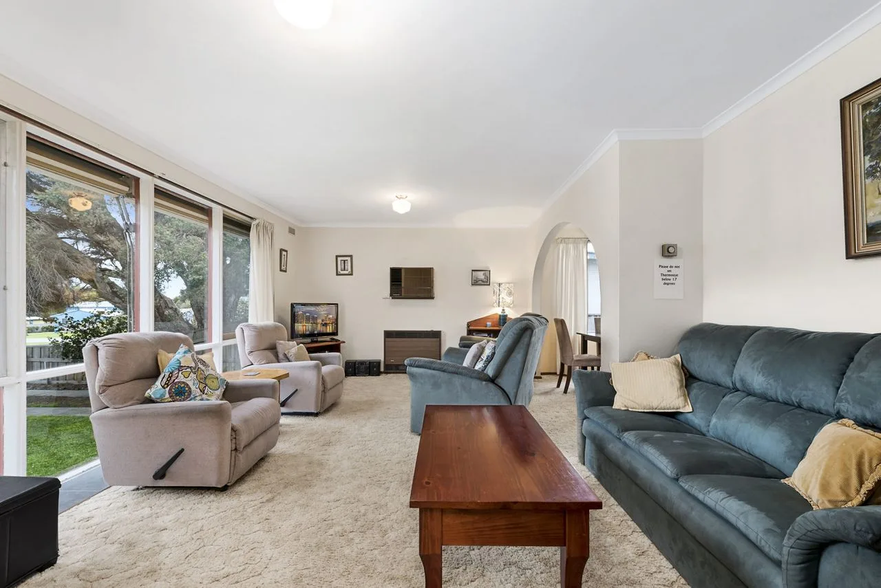 Living room with seating arranged around a wooden coffee table.