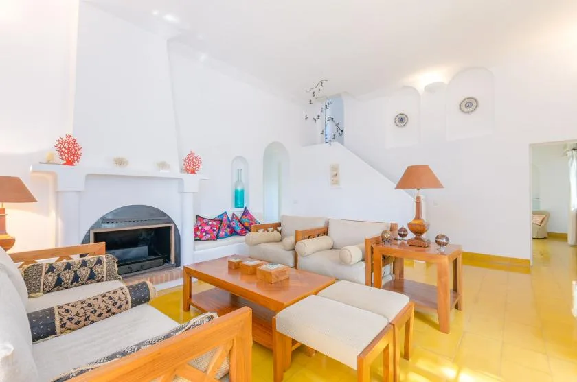 Una sala luminosa con asientos alrededor de una chimenea y una mesa de centro.