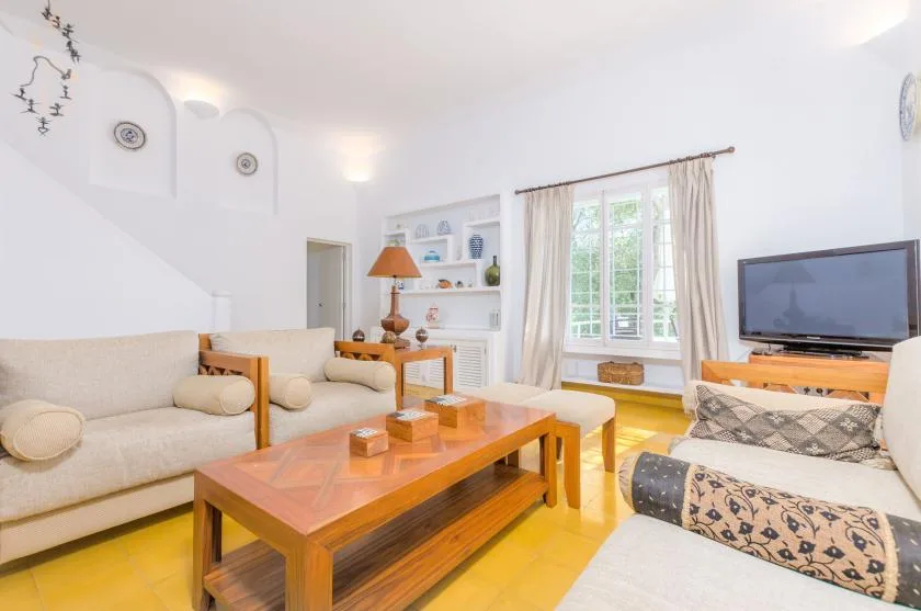 Una sala luminosa con asientos, mesas de madera y una ventana grande.