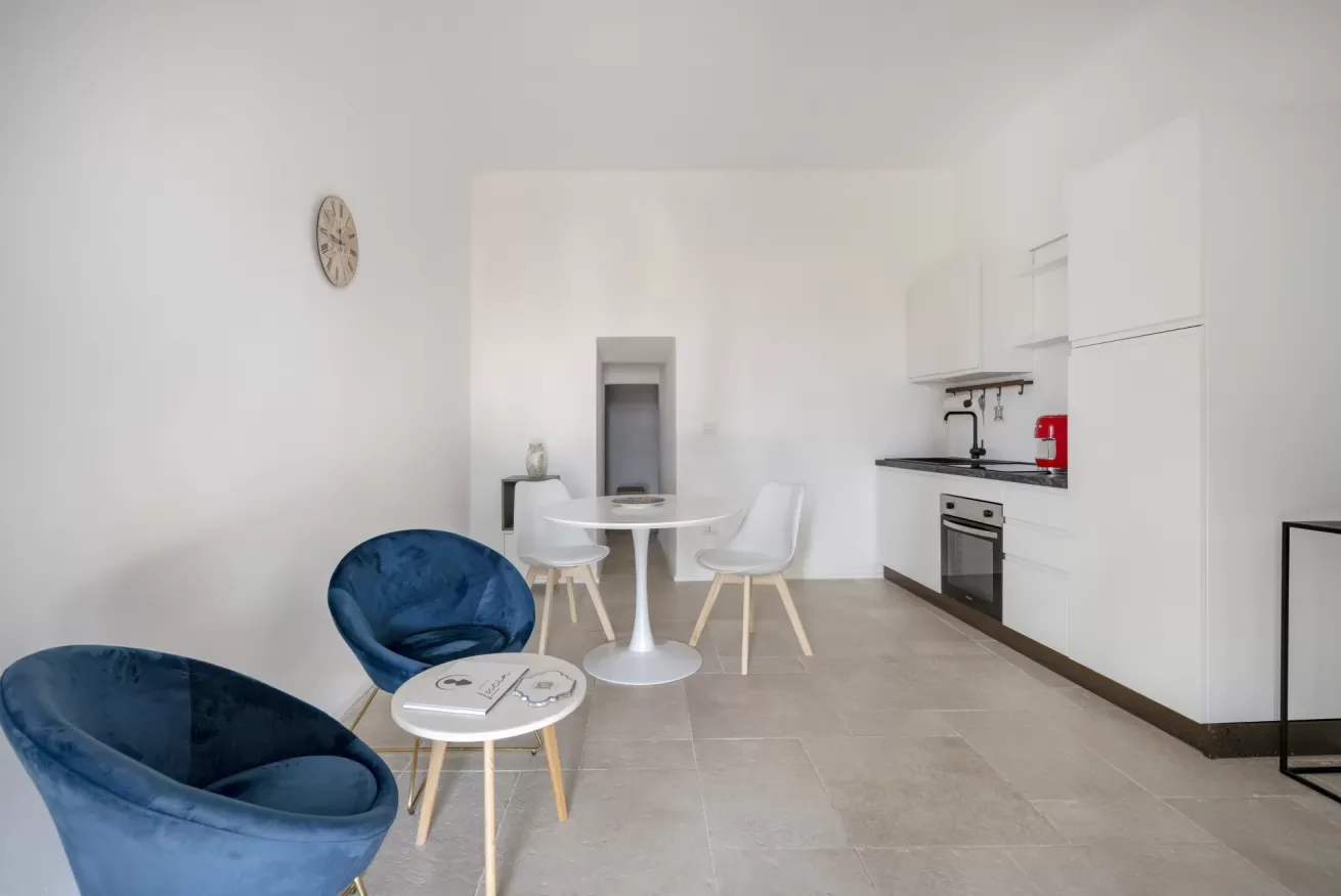 A bright kitchen and dining area with white cabinetry and a small table.