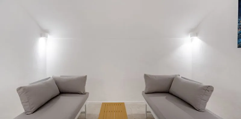 A bright seating area with two gray sofas facing a small wooden table.