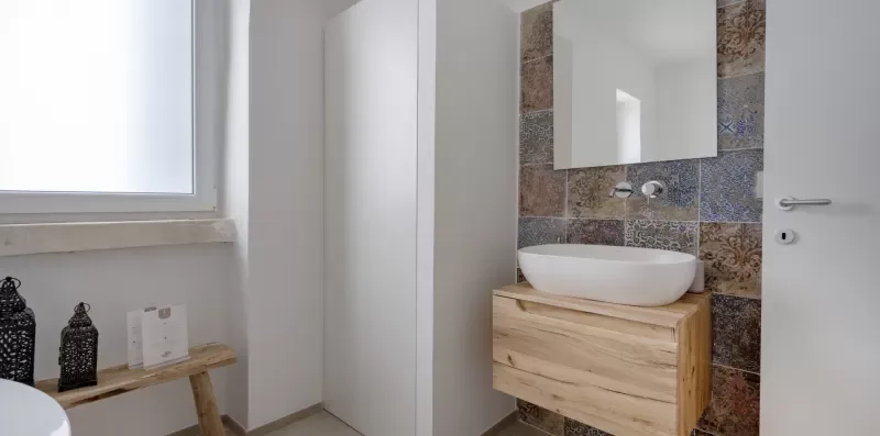 A bright bathroom with a vessel sink and a window.