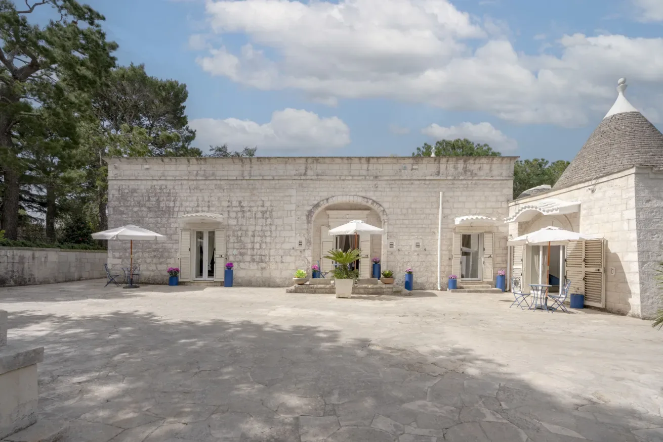 A stone courtyard with arched entrances and outdoor seating.