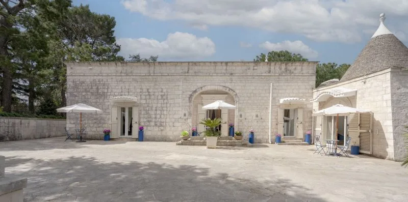 A stone courtyard with several arched doorways and outdoor seating.
