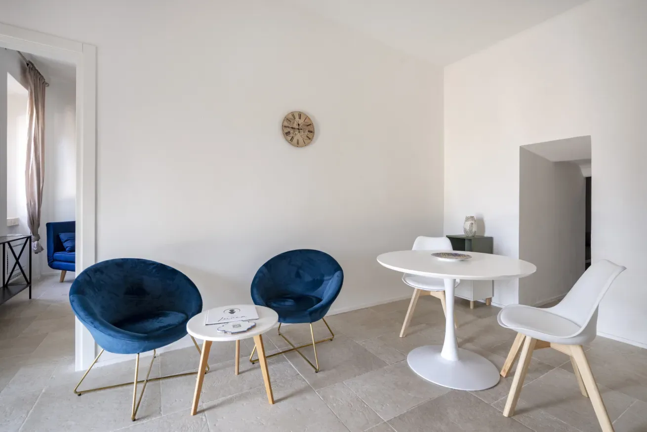 A bright sitting area with blue seating and a small white table.