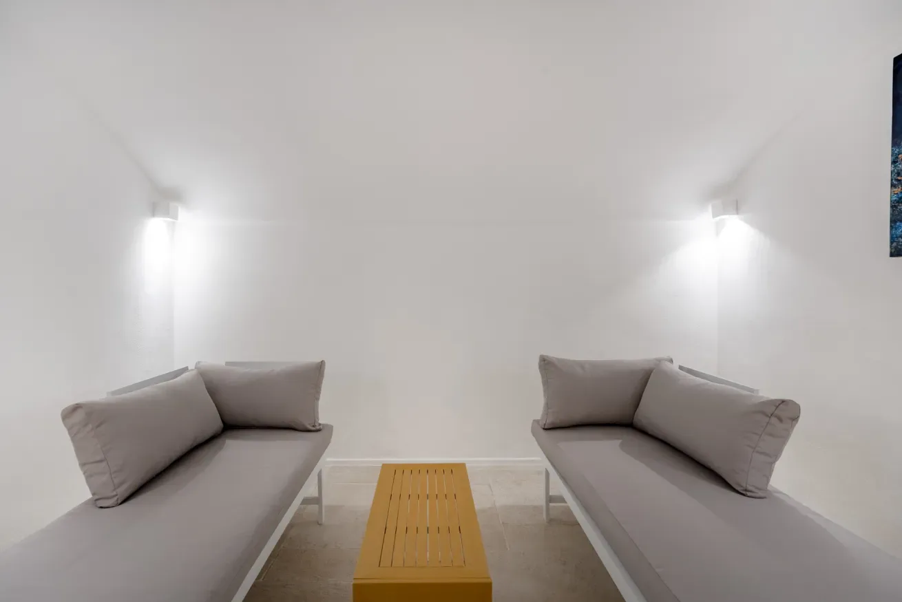 A bright seating area with two gray sofas facing a wooden coffee table.