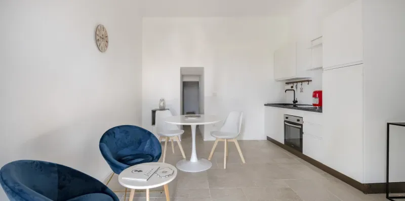 A bright kitchen and dining area with a small table and seating.