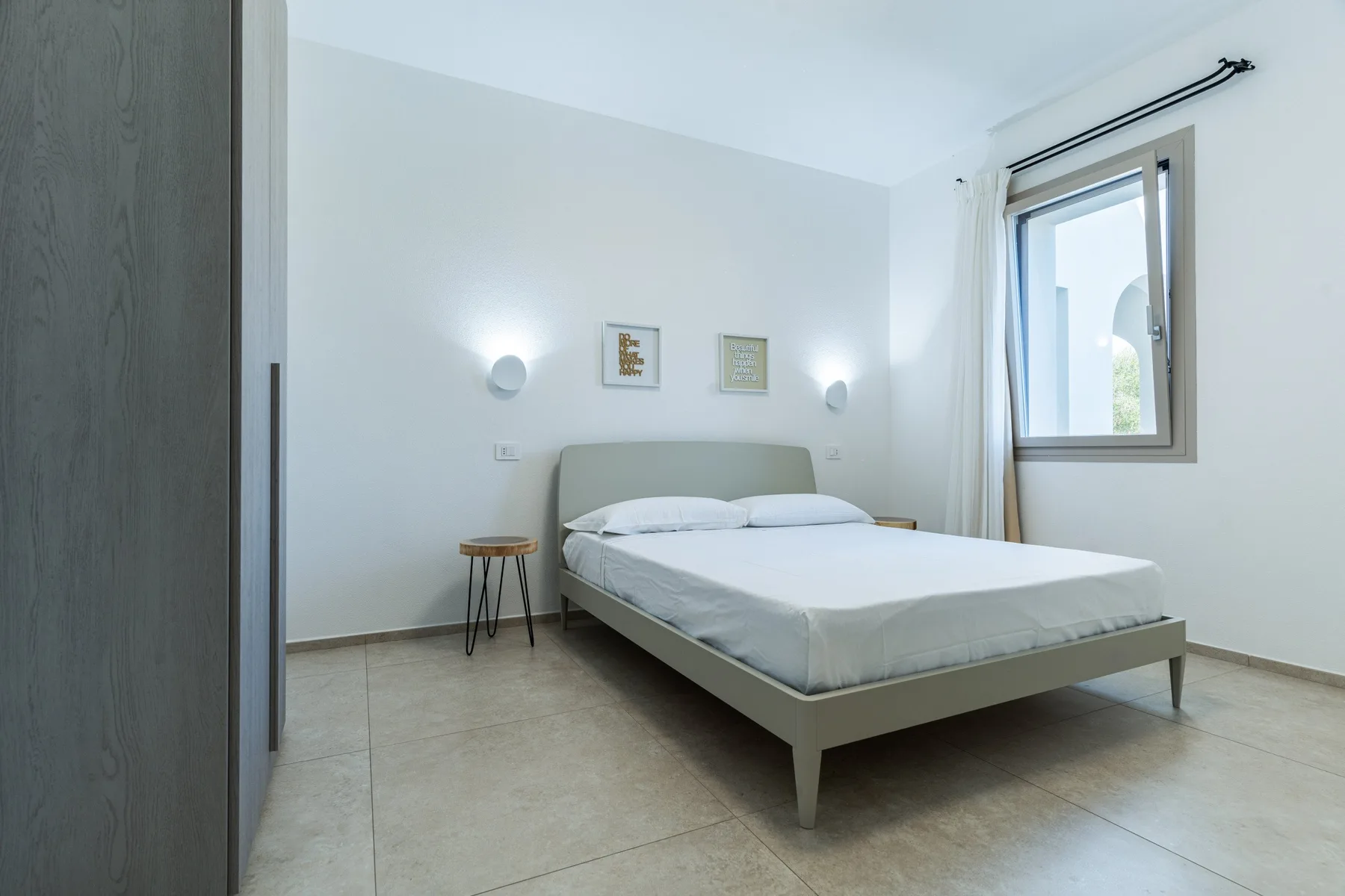 A bright bedroom with a bed and a window.