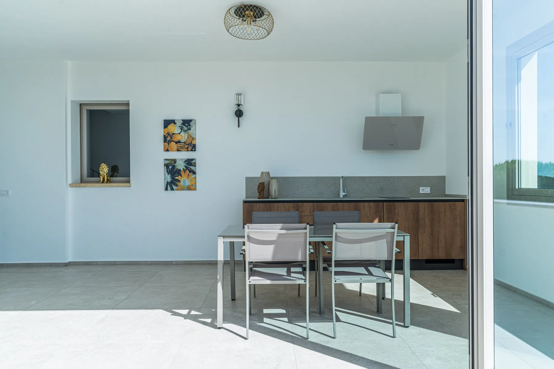 A bright dining area with a table and chairs beside a kitchen counter.