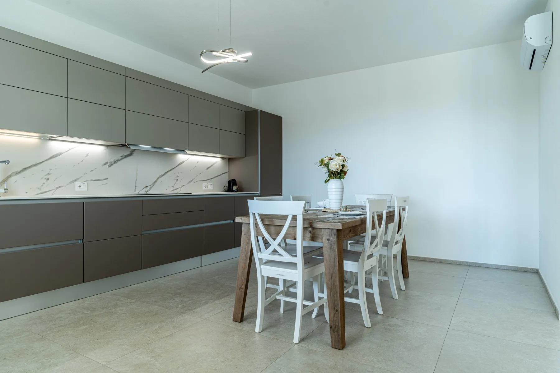 A modern kitchen and dining area with a table and seating.