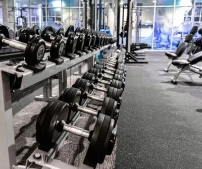 Gimnasio con mancuernas y bancos.