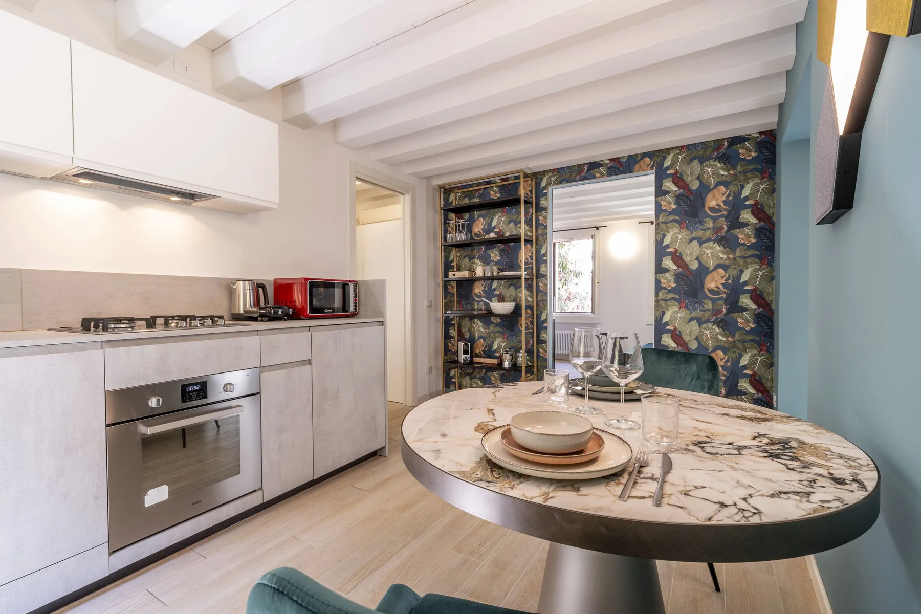 A dining area with a round table beside a compact kitchen.