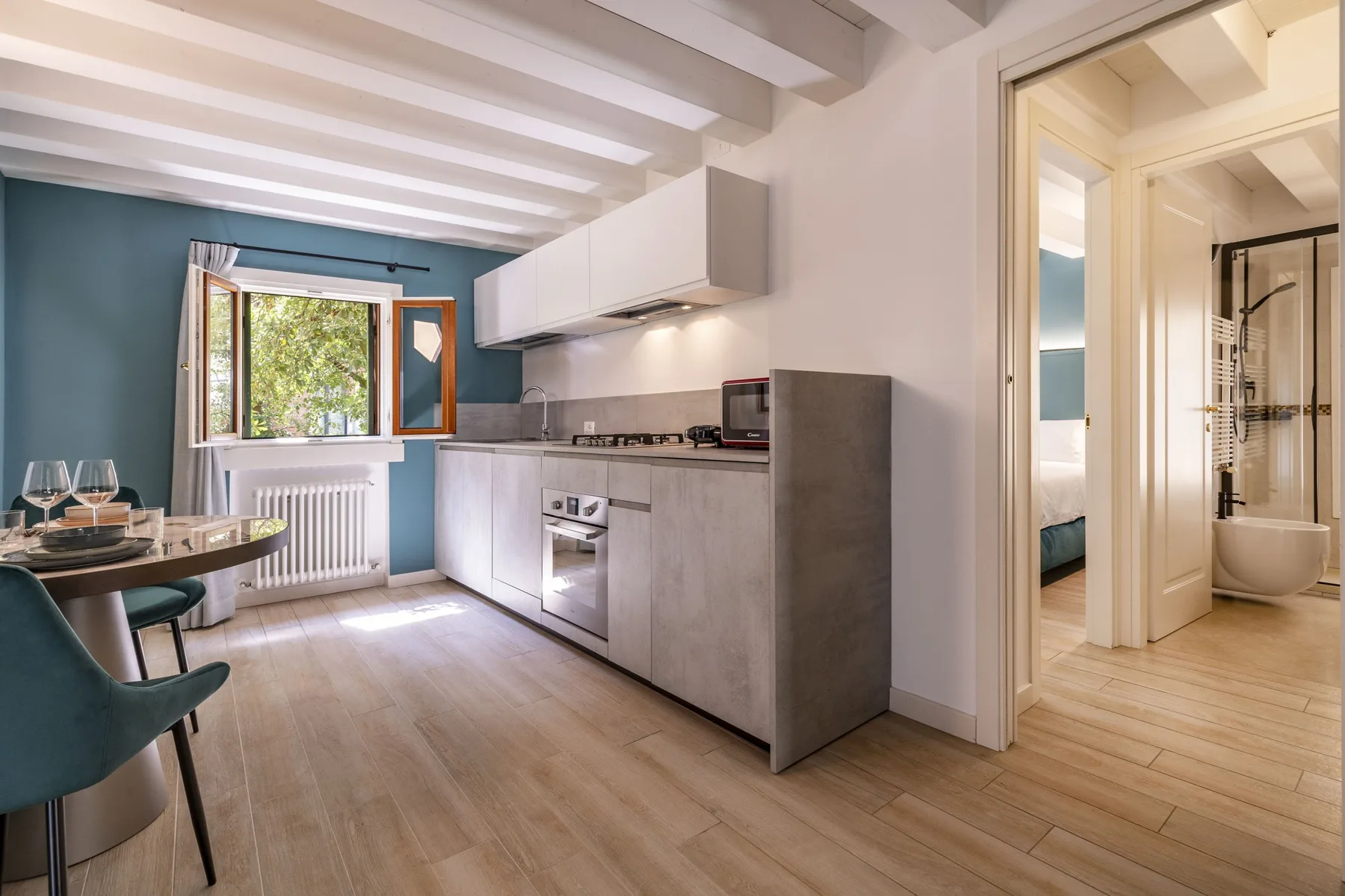 A compact kitchen with a dining table and an adjoining bathroom.