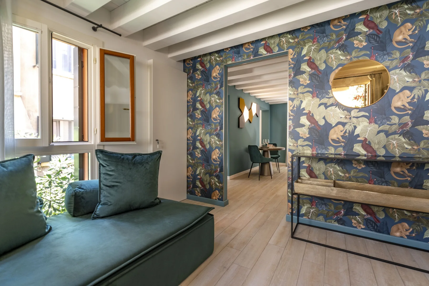 A colorful lounge with teal seating and patterned wallpaper around a doorway.